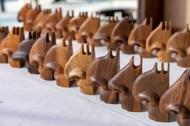 Bir sıra ahşap heykel masanın üzerine dizilmiştir. Heykelciklerin hepsi farklı şekil ve boyutlarda, ama hepsinin tasarımı aynı. Düzen ve düzen kavramı