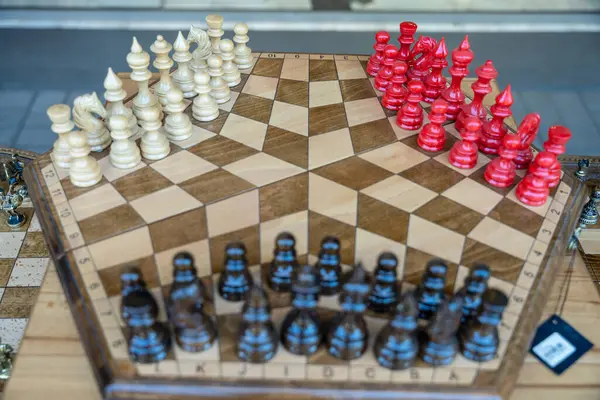 Kırmızı ve siyah taşları olan tahta bir satranç tahtası. Tahta beşgen şeklinde.