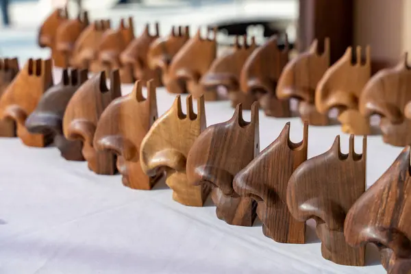 Bir sıra ahşap heykel masanın üzerine dizilmiştir. Heykelciklerin hepsi farklı şekil ve boyutlarda, ama hepsinin tasarımı aynı. Düzen ve düzen kavramı