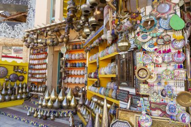 Sergilenen birçok farklı renkli eşyanın olduğu bir mağaza. Mağaza vazolar, kaseler ve diğer dekoratif eşyalar da dahil olmak üzere birçok farklı renkli eşyayla dolu. Mağaza ışıl ışıl.