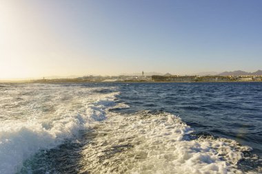 Okyanus sakin ve gökyüzü mavi. Su beyaz ve gökyüzü berrak.