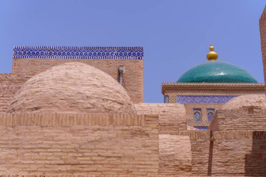 Tepesinde yeşil kubbe olan bir bina. Kubbe mavi çatılı bir binanın üstünde.