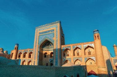 Mavi ve beyaz fayansları olan büyük bir bina. Bina yabancı bir ülkede. Binada bir sürü pencere var.