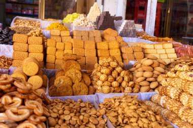 Farklı türde kurabiye ve atıştırmalıklarla dolu bir masa. Çikolata parçacıklı, yulaf ezmeli, kuru üzümlü ve fıstık ezmeli kurabiyeler de dahil olmak üzere pek çok farklı kurabiye türü vardır.