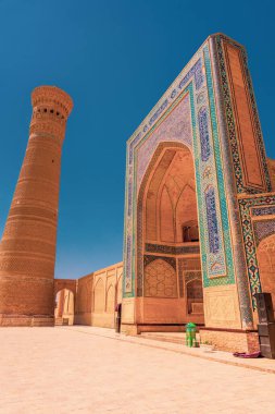 Önünde yeşil çöp kutusu olan yüksek bir bina. Bina kahverengi.