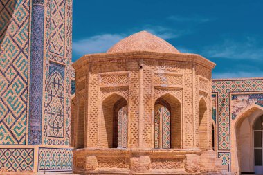 Tepesi kubbeli ve küçük pencereli bir bina. Bina bir avluda. Avlu tuğla duvarlarla çevrili.