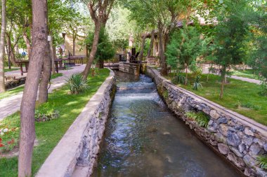 Parktan geçen küçük bir dere. Dere taştan bir duvarla çevrili. Parkta birkaç ağaç var, biri suya yakın olan.