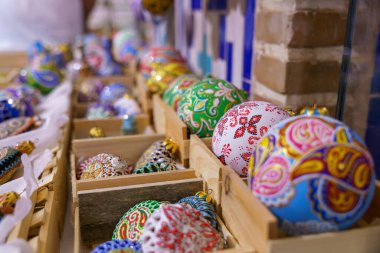 Ahşap kutularda renkli cam süsler sergileniyor. Kelebekli ve desenli olanlar da dahil olmak üzere pek çok farklı renk ve tasarım var.