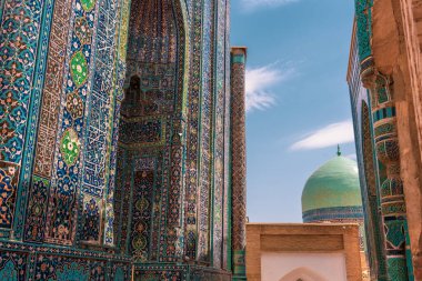 Tepesinde kubbe olan mavi ve yeşil bir bina. Bina yabancı bir ülkede.