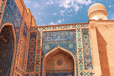 Binanın duvarında mavi ve beyaz bir tasarım var. Mavi ve beyaz tasarım karmaşık ve detaylı, birçok farklı şekil ve desenle. Bina tuğladan yapılmış ve tepesinde bir kubbe var.