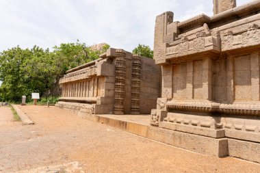 Taş duvarı ve taş sütunu olan taş bir bina. Bina toprak bir yol ile çevrili.
