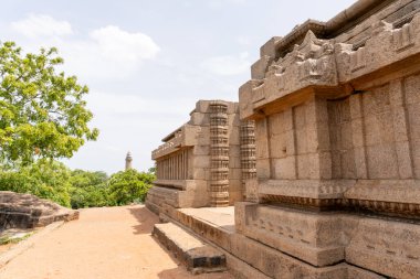 Arkasında ağaç olan taş bir bina. Bina eski ve çok detay içeriyor.