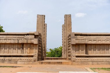 Ortasında büyük bir kemer olan taş bir duvar. Kemer yolu açık ve duvar taştan yapılmış. Sahnenin ihtişam ve tarih duygusu var, taş duvar gibi.
