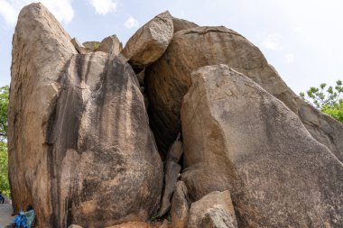 İçinde küçük bir delik olan büyük bir kaya oluşumu. Delik kayalarla çevrili ve o doğal bir mağara. Sahne hayranlık ve merak uyandırır.