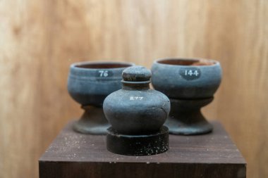 Chennai, Tamil Nadu, Hindistan - 02.07.2025: Üzerinde numaralar olan üç vazo ahşap bir masada oturuyor. Chennai 'de sayılar 74, 14 ve 14.