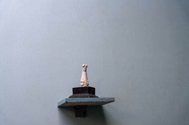 Chennai, Tamil Nadu, Hindistan - 02.07.2025: Küçük beyaz bir köpek heykeli bir rafta duruyor. Rafta bir duvar var. Chennai 'de.