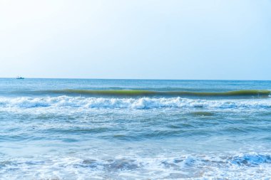 Chennai, Tamil Nadu, Hindistan - 02.07.2025: Kıyıya yakın okyanusta bir tekne var. Su mavi ve gökyüzü berrak. Chennai 'de.