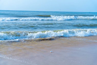 Chennai, Tamil Nadu, Hindistan - 02.07.2025: Sahilde küçük beyaz bir nesne var. Kumsal kumlu ve okyanus mavi. Chennai 'de.