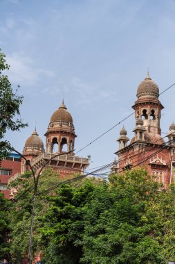 Chennai, Tamil Nadu, Hindistan - 02.07.2025: İki kubbesi ve bir saat kulesi olan yüksek bir bina. Bina ağaçlarla çevrili. Chennai 'de.
