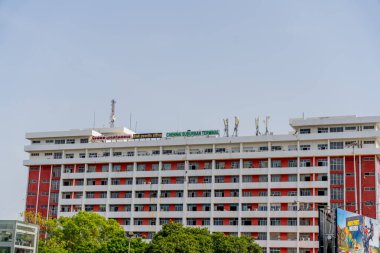 Chennai, Tamil Nadu, Hindistan - 02.07.2025: Beyaz çizgili büyük kırmızı bir bina. Binanın tepesinde yeşil bir tabela var. Chennai 'de.