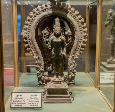 Chennai, Tamil Nadu, Hindistan - 02.07.2025: Kafasında yılan olan bir kadın heykeli cam bir kutuda sergilenmektedir. Heykel Durga 'nın. Chennai 'de.