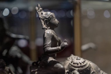 Chennai, Tamil Nadu, Hindistan - 02.07.2025: At üzerinde oturan bir kadın heykeli. Heykel siyah ve altın çerçeveli. Chennai 'de.