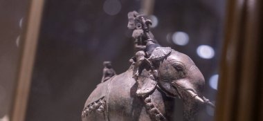 Chennai, Tamil Nadu, Hindistan - 02.07.2025: Üzerinde bir adam olan gümüş bir fil heykeli. Heykel cam bir kutunun içinde. Chennai 'de.