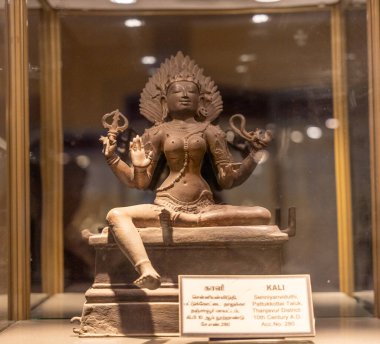 Chennai, Tamil Nadu, Hindistan - 02.07.2025: Heykel üzerinde oturan bir kadın heykeli. Heykelin adı Kali. Heykel cam bir kutunun içinde. Chennai 'de.