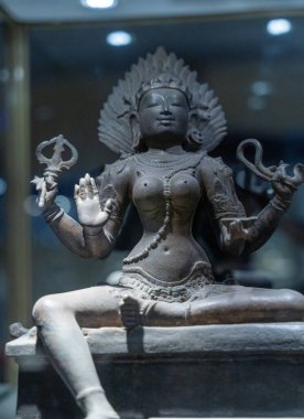 Chennai, Tamil Nadu, Hindistan - 02.07.2025: Taş bir levhada oturan bir kadın heykeli. Heykel bir tanrıçaya ait ve bir taç takıyor. Chennai 'de.