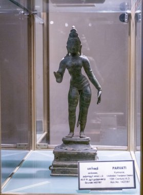 Chennai, Tamil Nadu, Hindistan - 02.07.2025: Cam bir kutuya yerleştirilmiş, başlıklı ve elini kaldırmış bir kadının bronz heykeli. Chennai 'de.