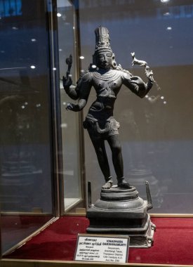 Chennai, Tamil Nadu, Hindistan - 02.07.2025: Elinde kuş olan bir adamın heykeli. Heykel siyah ve cam bir kutunun içinde. Chennai 'de.