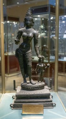 Chennai, Tamil Nadu, Hindistan - 02.07.2025: Çocuk tutan bir kadın heykeli. Heykel cam bir kutunun içinde. Kadın bir kolye takıyor. Chennai 'de.