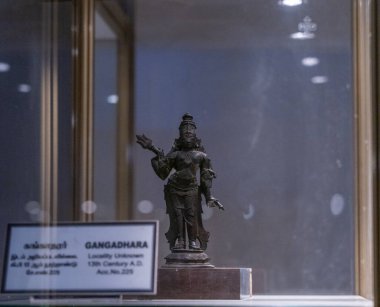 Chennai, Tamil Nadu, Hindistan - 02.07.2025: Kılıç tutan bir kişinin bronz heykeli cam bir kutuda sergilenmektedir. Chennai 'de.