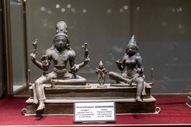 Chennai, Tamil Nadu, Hindistan - 02.07.2025: Bankta oturan bir kadın ve erkeğin heykeli. Adam elinde bir sopa tutuyor. Chennai 'de.