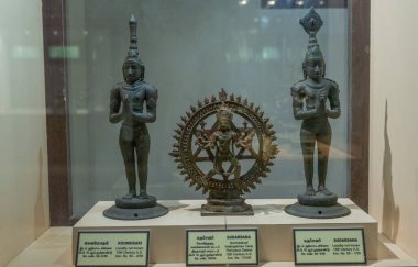 Chennai, Tamil Nadu, Hindistan - 02.07.2025: Cam bir kutuda üç heykel sergilenmektedir. Ortadaki heykel direksiyon tutan bir kadın. Chennai 'de.