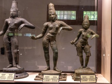 Chennai, Tamil Nadu, Hindistan - 02.07.2025: Cam bir kutuda üç insan heykeli sergileniyor. İlk heykel şapkalı bir adamın. Chennai 'de.