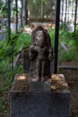 Chennai, Tamil Nadu, Hindistan - 02.07.2025: Taş bir heykel üzerinde oturan bir kişi. Kaidede 