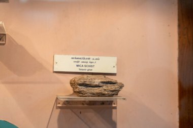 Chennai, Tamil Nadu, Hindistan - 02.07.2025: Rafta Mica Scht yazan bir tabelanın yanında bir kaya var. Kaya kahverengidir ve pürüzlü bir dokusu vardır. Chennai 'de.