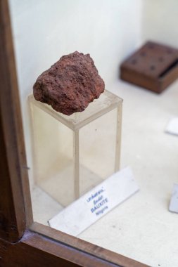 Chennai, Tamil Nadu, Hindistan - 02.07.2025: Cam bir kabın içinde bir kaya sergileniyor. Kaya kahverengidir ve beyaz etiketinde 