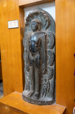 Chennai, Tamil Nadu, Hindistan - 02.07.2025: boynunda yılan olan bir adamın heykeli. Heykel siyah ve taştan yapılmıştır. Chennai 'de.