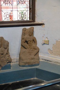 Chennai, Tamil Nadu, Hindistan - 02.07.2025: Bir kadın heykeli pencerenin önündeki bir kayanın üzerinde oturuyor. Heykel taştan yapılmıştır. Chennai 'de.