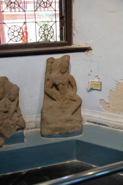 Chennai, Tamil Nadu, Hindistan - 02.07.2025: Bir kadın heykeli mavi duvarlı bir odada bir kayanın üzerinde oturuyor. Chennai 'de.