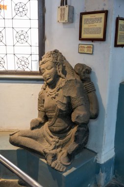 Chennai, Tamil Nadu, Hindistan - 02.07.2025: Çıkıntıda oturan bir kadın heykeli. Heykel taştan yapılmıştır ve bir çıkıntının üzerinde oturmaktadır. Chennai 'de.