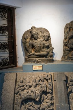 Chennai, Tamil Nadu, Hindistan - 02.07.2025: Taş bir levhada oturan bir erkek ve kadının heykeli, yanında 