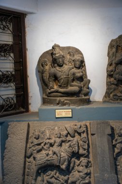 Chennai, Tamil Nadu, Hindistan - 02.07.2025: Taş bir levhada oturan kadın ve erkek heykeli. Heykelin yanında bir işaret var. Chennai 'de.