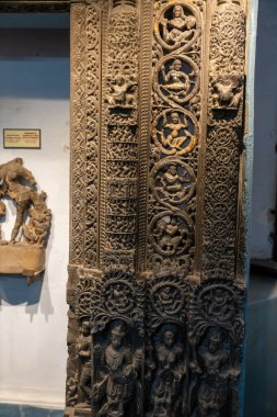 Chennai, Tamil Nadu, Hindistan - 02.07.2025: Çocuklu bir kadının ahşap oyması. Oyma bir duvarda. Chennai 'de.