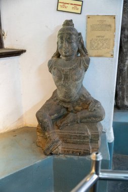 Chennai, Tamil Nadu, Hindistan - 02.07.2025: Çıkıntıda oturan bir adamın heykeli. Heykel taştan yapılmıştır ve bir çıkıntının üzerinde oturmaktadır. Chennai 'de.