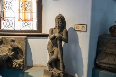 Chennai, Tamil Nadu, Hindistan - 02.07.2025: Elinde sopa olan bir adamın heykeli müzede sergileniyor. Heykel kilden yapılmıştır. Chennai 'de.