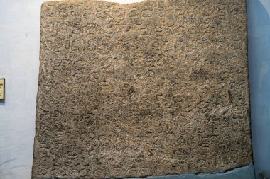 Chennai, Tamil Nadu, Hindistan - 02.07.2025: Üzerinde yazı olan büyük bir taş levha. Yazı yabancı bir dilde yazılmış. Levha kahverengi. Chennai 'de.