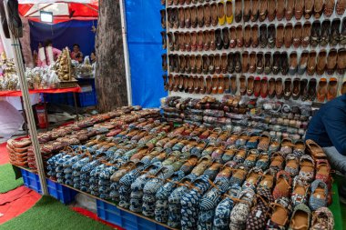 Chennai, Tamil Nadu, Hindistan - 02.07.2025: Mavi arka planda bir ayakkabı gösterisi. Çok farklı renkler ve ayakkabı stilleri var. Chennai 'de.